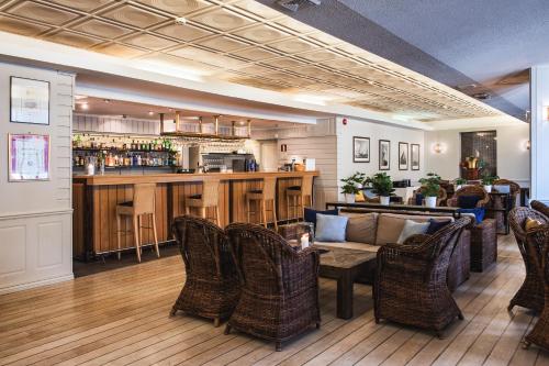 a lobby with a couch and chairs and a bar at Hankø Hotell & Spa in Gressvik
