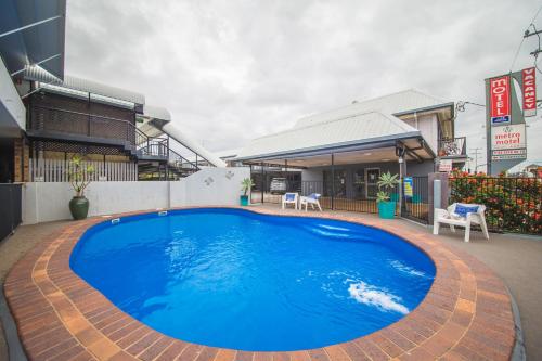 a large blue swimming pool in front of a building at Metro Motel Rockhampton in Rockhampton