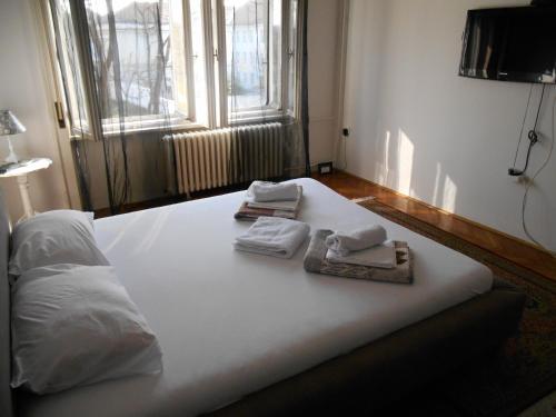 a bed with towels on top of it with a window at Dunavski Park in Novi Sad