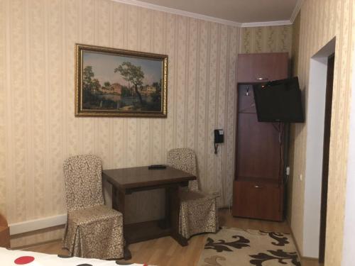 a room with a table and chairs and a television at Львівське Передмістя in Lviv