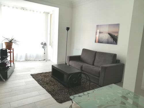ein Wohnzimmer mit einem Sofa und einem Tisch in der Unterkunft 6 Rue de Castillon Appartement in Beausoleil