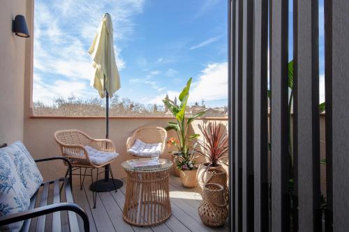 balcone con sedie, tavolo e ombrellone di Hotel Oasis a Barcellona