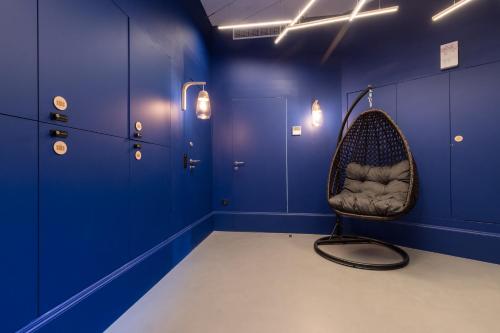 a room with a chair in a room with blue walls at L'Abeille - Boutique Apartments in Nice