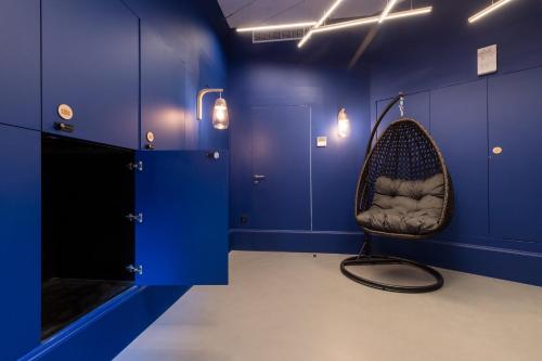 a room with a chair in a room with blue walls at L'Abeille - Boutique Apartments in Nice