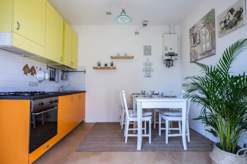 a kitchen with yellow cabinets and a table with chairs at Casali Marchigiani - Ville vacanza private con piscina in Ostra