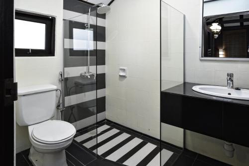 uma casa de banho com um WC e um lavatório em Holiday Villa Beach Resort Cherating em Cherating