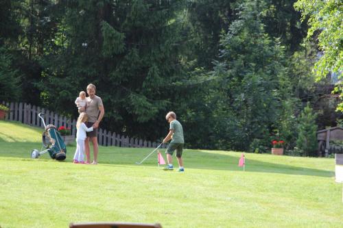 a family playing a game of golf in a yard at Villa Ortensia in San Vigilio Di Marebbe