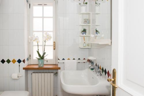 baño blanco con lavabo y ventana en Villa Mare Tra Cielo e Mare, en Gaeta