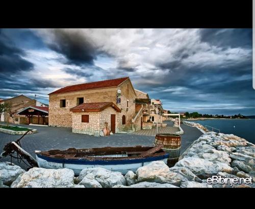 a boat parked next to a building on the water at Apartment Mate in Bibinje