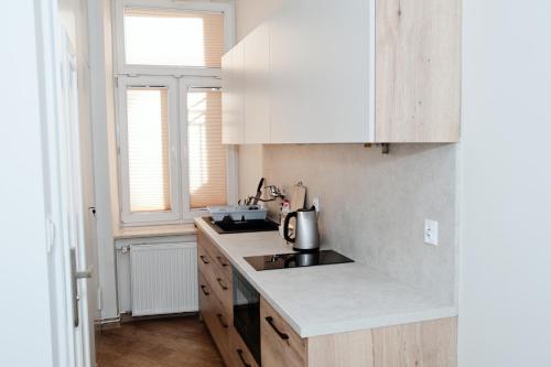 a kitchen with white cabinets and a counter top at Rodmos Hostel in Lublin
