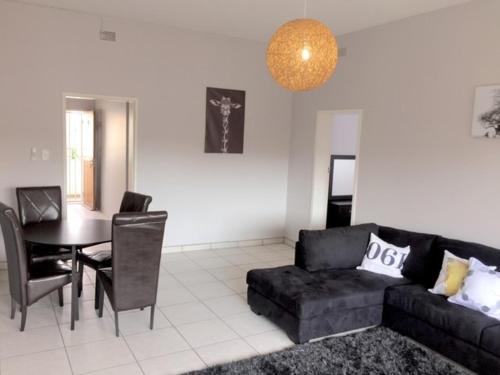 a living room with a black couch and a table at Stern self catering apartments in Windhoek