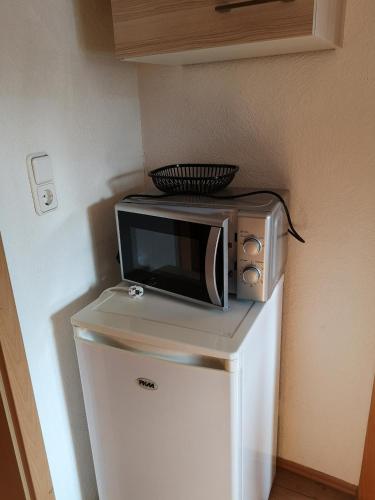 a microwave sitting on top of a refrigerator at Hotel Löhr in Baden-Baden