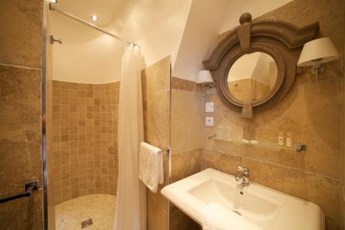 La salle de bains est pourvue d'un lavabo, d'un miroir et d'une douche. dans l'établissement La Maison d'Emilie, à Houlgate