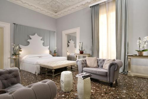 a bedroom with a bed and a couch and chairs at Al Palazzo del Marchese di Camugliano Residenza d'Epoca in Florence