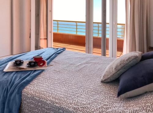Un dormitorio con una cama con una bandeja de comida. en Apartamento Leo Playa de San Juan en Alicante