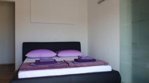 a bedroom with a bed with pink and purple pillows at Apartments Milas in Trogir