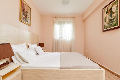a bedroom with a large bed and a window at Apartments Barbara in Kotor