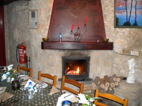 a dining room table with a fire place in front of it at Kiniras Traditional Hotel & Restaurant in Paphos