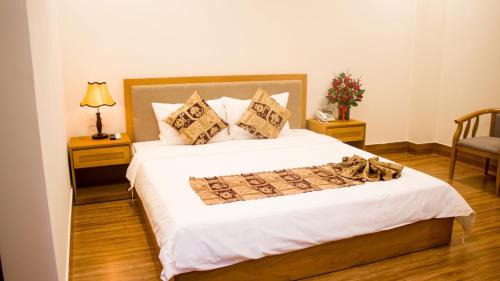 a bedroom with a large bed with white sheets and pillows at Hoài Thương Hotel in Pleiku
