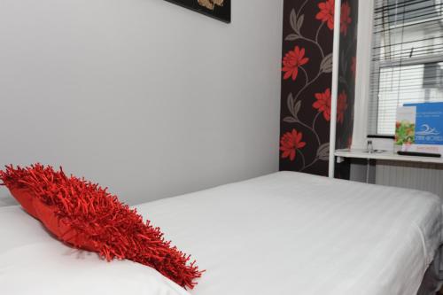 a red pillow sitting on top of a bed at Suncliff Hotel - OCEANA COLLECTION in Bournemouth