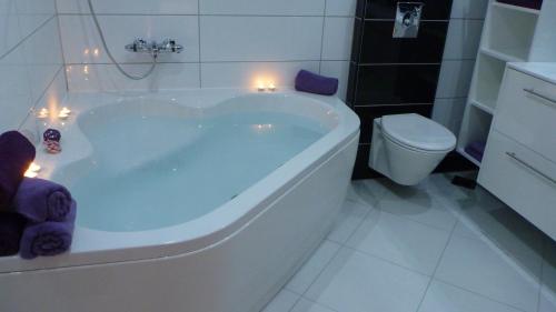 a white bath tub in a bathroom with a toilet at Apartments Milas in Trogir