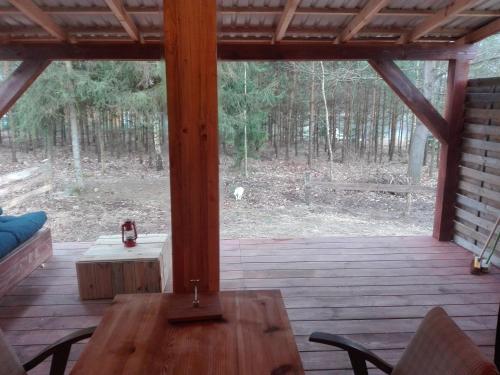 a screened in porch with a wooden table and chairs at Maly Domek Zalesie in Barczewo