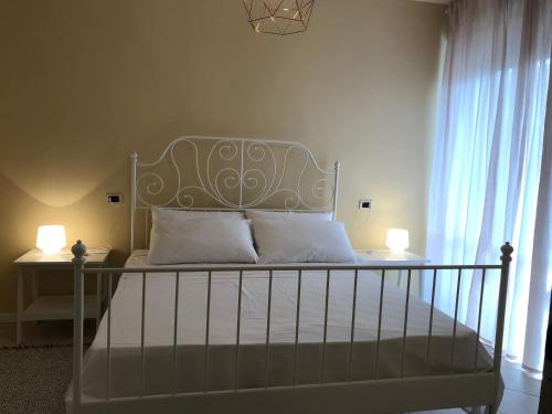 a bed with white sheets and pillows in a bedroom at La Coccinella Apartment in Lucca