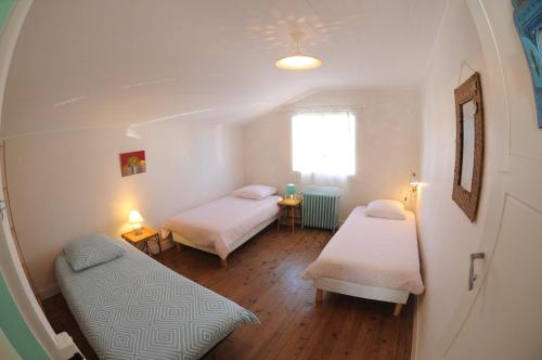ein kleines Zimmer mit zwei Betten und einem Fenster in der Unterkunft La villa tamaris maison à partager in Vieux-Boucau-les-Bains
