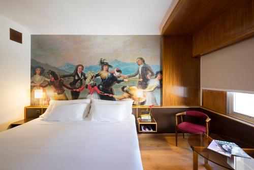 a hotel room with a bed and a painting on the wall at Hotel Goya in Zaragoza