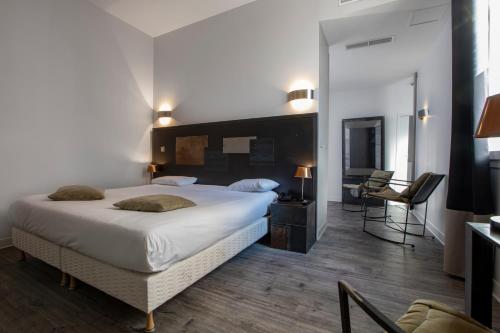 sypialnia z dużym łóżkiem i biurkiem w obiekcie Hôtel De Paris w mieście Sète