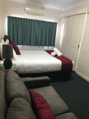 a hotel room with two beds and a couch at O'Shea's Royal Hotel in Goondiwindi