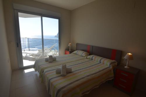a bedroom with a bed with a view of the ocean at Apartamentos Entremares - Grupo Antonio Perles in Calpe