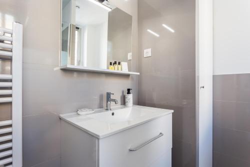 Baño blanco con lavabo y espejo en CMG Champs Elysées - Boetie 4DD, en París