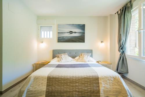a bedroom with a bed and a painting on the wall at Exclusive quietness in the heart of Madrid with Public Parking, Breakfast, 2 bathrooms in Madrid
