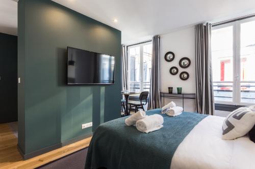 1 dormitorio con 1 cama y TV de pantalla plana en CMG Champs Elysées - Boetie 4DD, en París