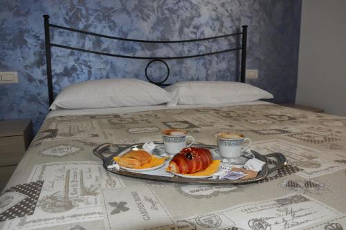 a tray of food on a bed with coffee and pastries at Albano Station Rooms in Pavona