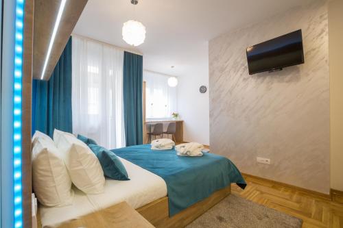 a bedroom with a bed with blue sheets and a tv at Thomas Residence in Belgrade