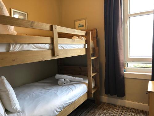 two bunk beds in a room with a window at The Arran Lodge & Arran Sleep Huts in Lamlash
