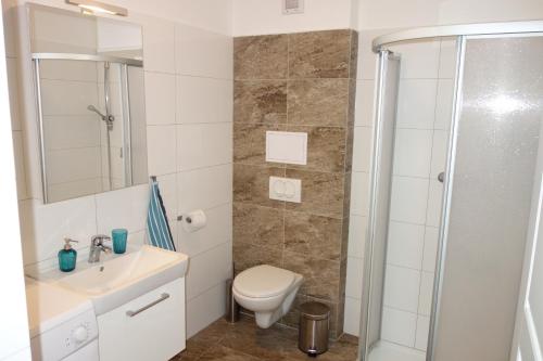 uma casa de banho com um lavatório e um chuveiro. em Lednicko-valtický apartmán em Hlohovec