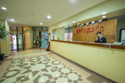 a man standing at a counter in a restaurant at Ramada Plaza by Wyndham Gence in Ganja