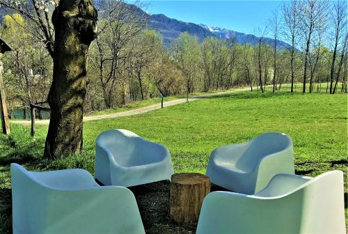 two blue chairs sitting next to a tree in a field at Cà Virò in Albosaggia