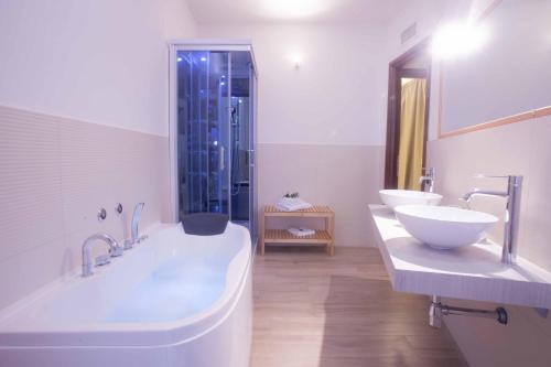 a bathroom with two sinks and a tub and a shower at Fior di Loto Sweetness in Cagliari