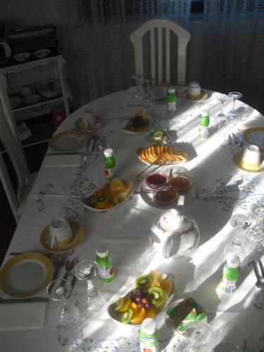 a white table with plates of food on it at Casa Teresinha in Sesimbra