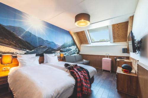a hotel room with two beds and a tv at Alpine Hotel by SnowWorld in Landgraaf