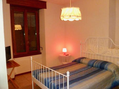 a bedroom with a white bed with a lamp at Casa Grazia in Lovero Valtellino