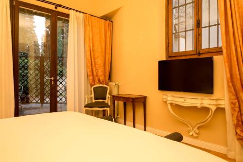 a bedroom with a bed and a flat screen tv at Art Hotel Villa Agape - Place of Charme in Florence
