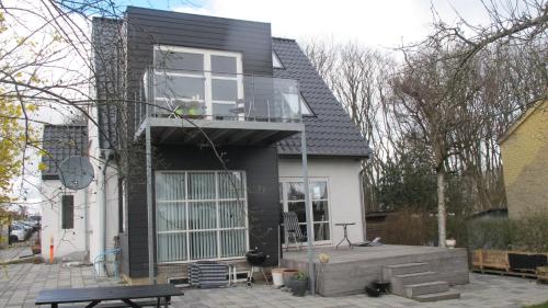 a house with a balcony and a patio at Guesthouse Sharon Apartments in Aarhus
