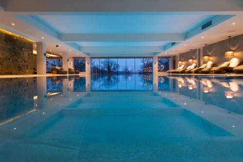 a swimming pool in a hotel with a view of the water at South Lodge in Lower Beeding