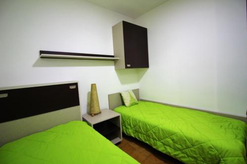 2 camas en una habitación con sábanas verdes en Global Immo 1034 Montserrat, en Roses