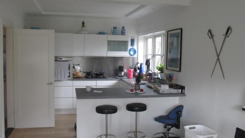a kitchen with a counter and two stools in it at Guesthouse Sharon Apartments in Aarhus